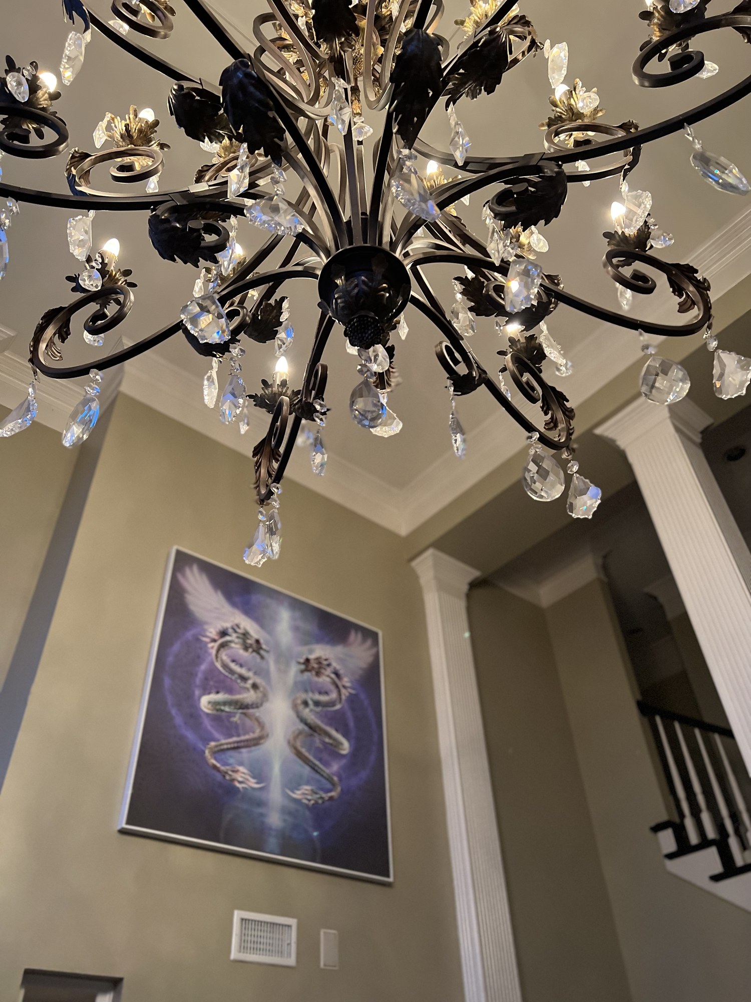 Alchemy: Prima Materia hung on a double-height wall beneath a crystal chandelier.