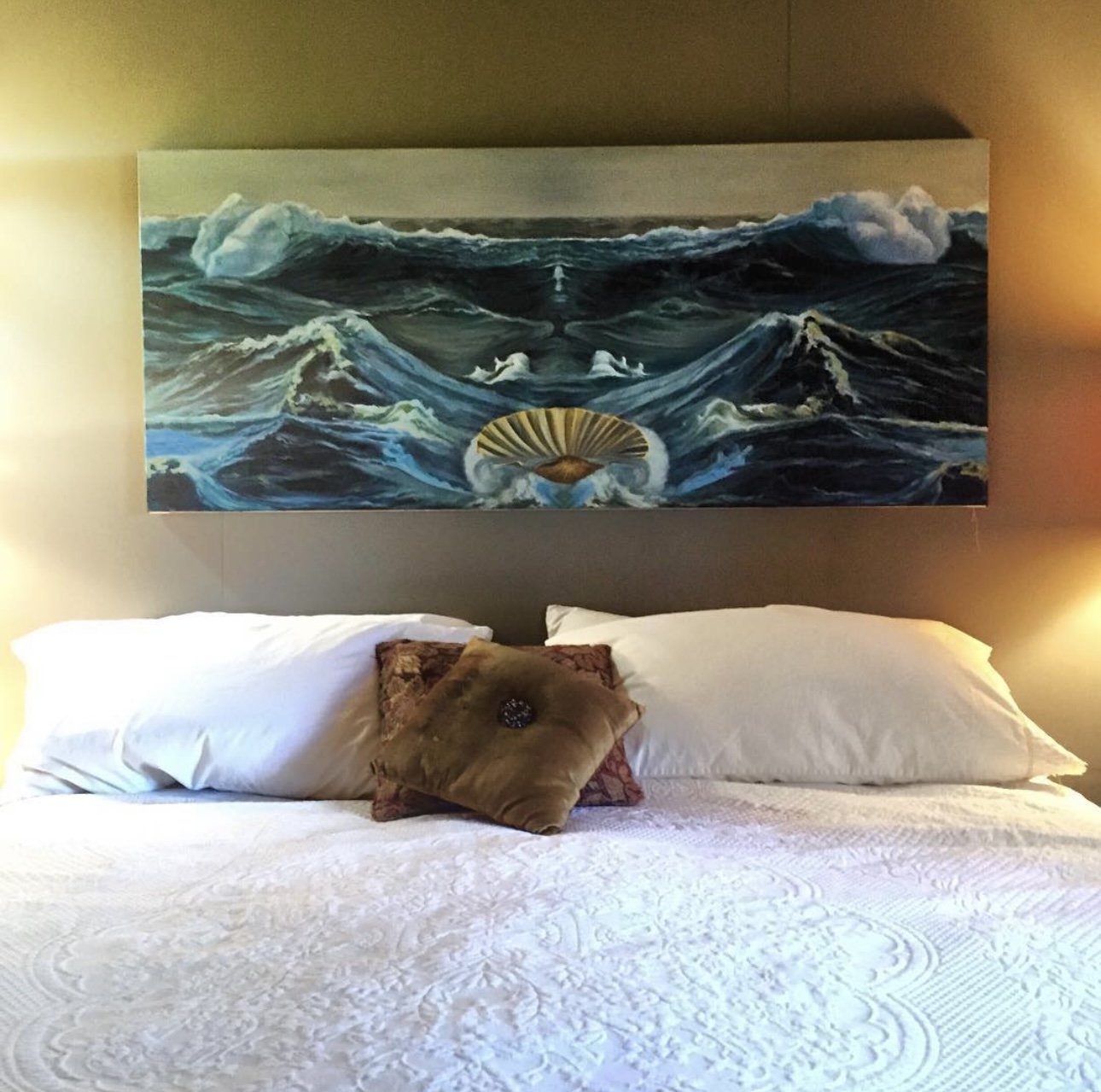 The Birth of Venus canvas edition installed above a bed, warm evening light